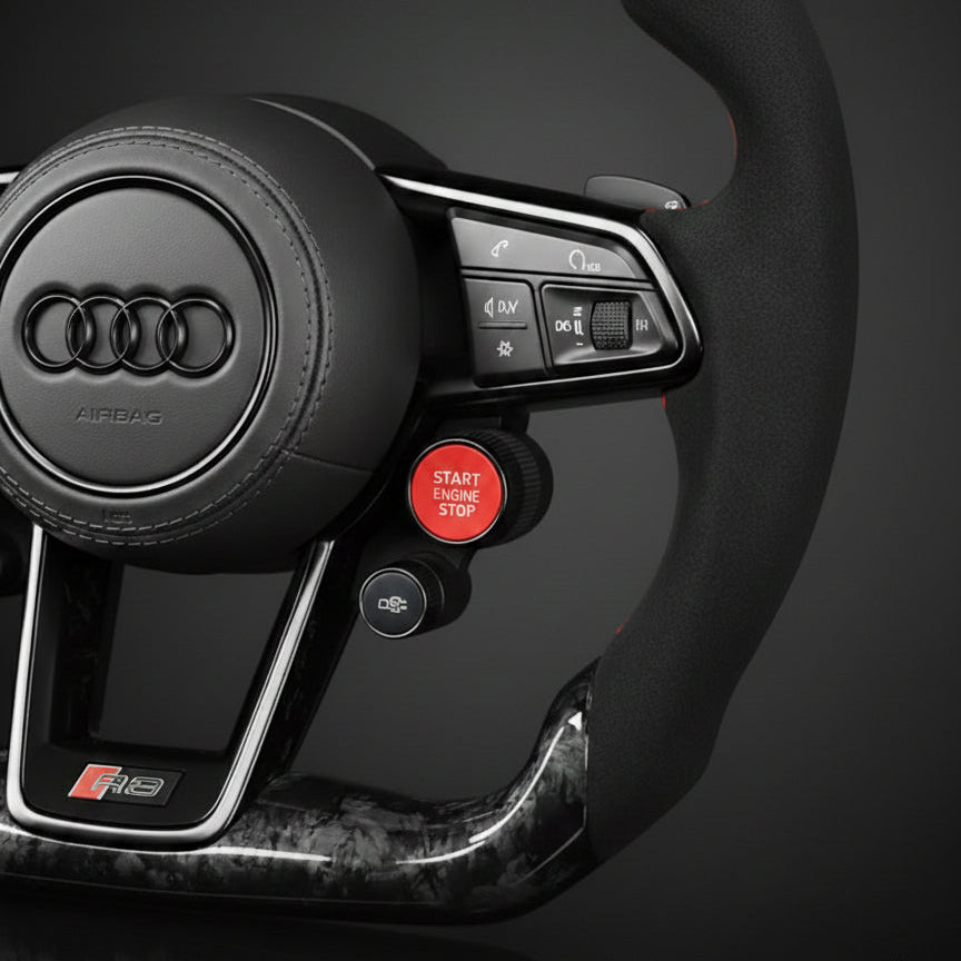Close-up of an Audi forged carbon steering wheel with controls on a dark background
