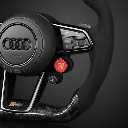 Close-up of an Audi forged carbon steering wheel with controls on a dark background