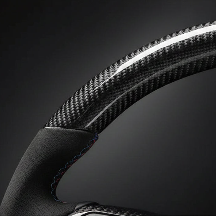 Close-up of a steering wheel with carbon fiber texture on a dark background