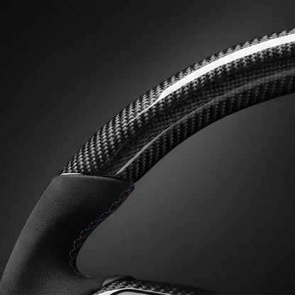 Close-up of a steering wheel with carbon fiber texture on a dark background